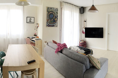 Modelo de salón para visitas abierto nórdico de tamaño medio sin chimenea con suelo de madera clara y televisor colgado en la pared