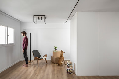 Imagen de salón abierto de tamaño medio con paredes blancas, suelo de madera en tonos medios y suelo marrón