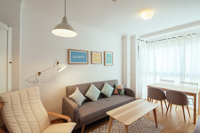 Modelo de salón para visitas cerrado nórdico pequeño sin chimenea y televisor con paredes blancas y suelo de madera en tonos medios