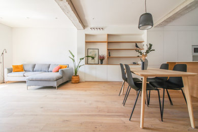 Imagen de salón abierto actual con suelo de madera en tonos medios y suelo marrón