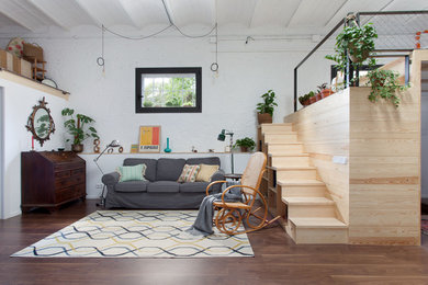 Offenes, Mittelgroßes, Repräsentatives, Fernseherloses Industrial Wohnzimmer mit weißer Wandfarbe und braunem Holzboden in Barcelona