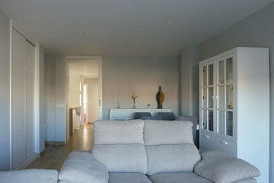 Imagen de salón abierto nórdico de tamaño medio sin chimenea con paredes grises, suelo de baldosas de porcelana, televisor independiente y suelo beige