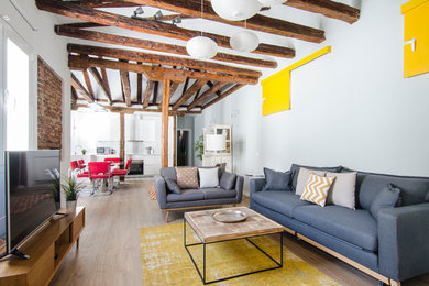 Ejemplo de salón para visitas abierto contemporáneo de tamaño medio sin chimenea con paredes azules, suelo de madera en tonos medios y pared multimedia