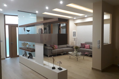 Diseño de salón abierto contemporáneo grande con paredes beige, suelo de baldosas de cerámica, televisor independiente y suelo beige