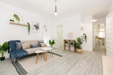Diseño de salón abierto nórdico de tamaño medio con paredes blancas, suelo de baldosas de porcelana, pared multimedia y suelo gris