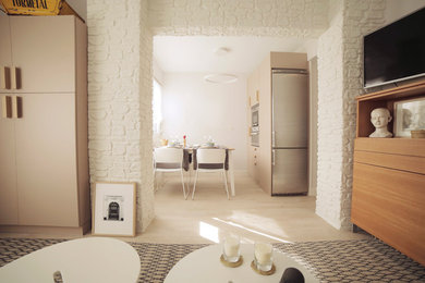 Modern inredning av ett litet allrum med öppen planlösning, med beige väggar, vinylgolv, en väggmonterad TV och beiget golv