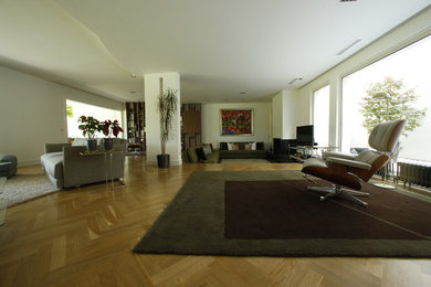 Imagen de salón para visitas abierto clásico renovado grande sin chimenea con paredes blancas, suelo de madera en tonos medios y televisor independiente