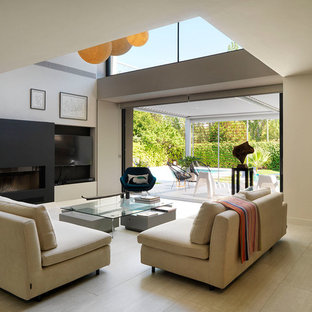 Diseño de salón abierto, minimalista, con paredes beige, chimenea lineal, televisor colgado en la pared y suelo beige