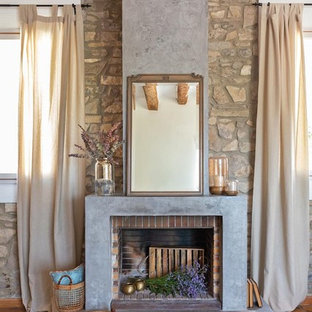 Imagen de salón mediterráneo, grande, con paredes blancas, chimenea tradicional y suelo marrón