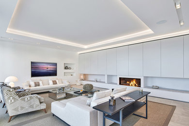 This is an example of a large contemporary formal open plan living room in Palma de Mallorca with white walls, a ribbon fireplace, a wall mounted tv and beige floors.