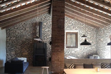 バルセロナにある高級な中くらいなラスティックスタイルのおしゃれなリビング (グレーの壁、コンクリートの床、薪ストーブ、金属の暖炉まわり、グレーの床) の写真