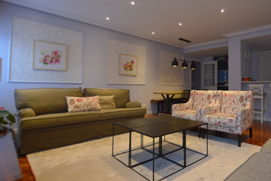Foto de salón abierto tradicional renovado grande con paredes azules, suelo de madera oscura y televisor independiente