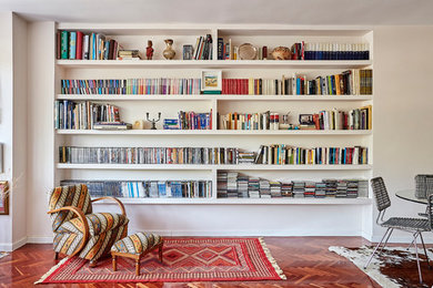 Imagen de biblioteca en casa abierta bohemia de tamaño medio con suelo de madera oscura, televisor independiente, suelo marrón y paredes beige
