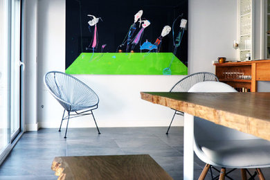 Modelo de salón con barra de bar abierto minimalista grande sin televisor con paredes blancas, suelo de baldosas de porcelana y suelo gris