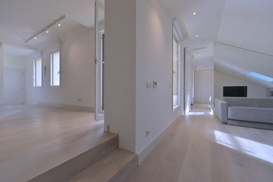 Modelo de salón abierto contemporáneo con paredes blancas y suelo de madera clara
