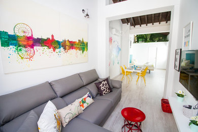 Immagine di un piccolo soggiorno minimal stile loft con pareti bianche, parquet chiaro, TV a parete e pavimento grigio