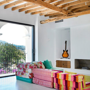 Modelo de salón mediterráneo con paredes blancas, suelo de cemento, chimenea tradicional y suelo gris