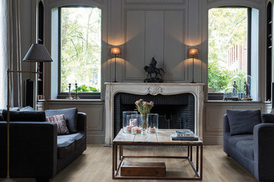 Imagen de salón para visitas abierto clásico grande sin televisor con paredes grises, suelo de madera en tonos medios y todas las chimeneas