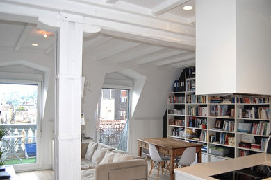 Modelo de salón abierto escandinavo de tamaño medio con paredes blancas, suelo de madera clara y televisor colgado en la pared