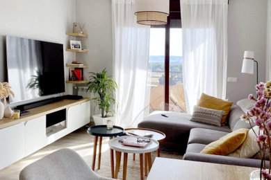 Ejemplo de salón abierto escandinavo con paredes grises, suelo de madera en tonos medios, chimeneas suspendidas, televisor colgado en la pared y suelo gris