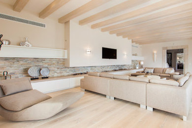 Ejemplo de salón para visitas cerrado nórdico grande con paredes beige, suelo de madera clara y televisor colgado en la pared
