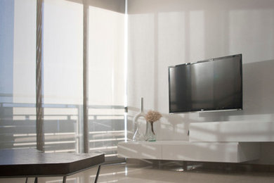 Bild på ett vardagsrum, med vita väggar och en väggmonterad TV