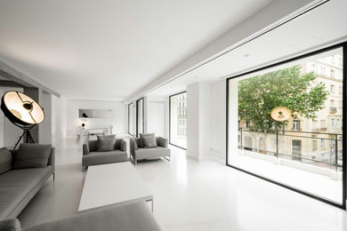 Foto de salón abierto minimalista extra grande con paredes blancas, suelo de piedra caliza, pared multimedia y suelo beige