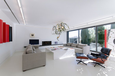 Imagen de salón para visitas abierto actual grande con paredes blancas, televisor independiente y chimenea lineal