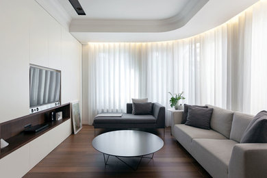 Imagen de salón abierto contemporáneo de tamaño medio con paredes blancas, suelo de madera oscura, pared multimedia y suelo marrón