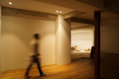 Imagen de salón abierto moderno grande con paredes blancas, suelo de madera en tonos medios, televisor colgado en la pared y suelo marrón