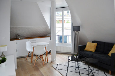 Idée de décoration pour un petit salon mansardé ou avec mezzanine nordique avec un mur blanc, parquet clair, aucune cheminée, un téléviseur indépendant et un sol beige.