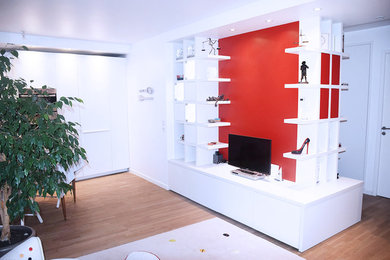 Réalisation d'un salon design de taille moyenne et ouvert avec un mur rouge, parquet clair, aucune cheminée, un sol marron et un téléviseur indépendant.