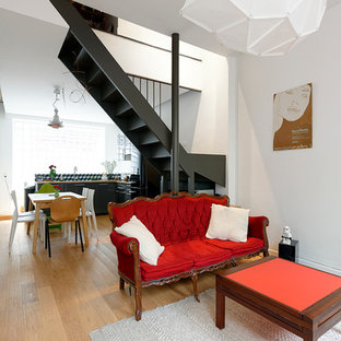 Idée de décoration pour un salon design de taille moyenne et ouvert avec un mur blanc, un sol en bois clair, aucune cheminée et aucun téléviseur.