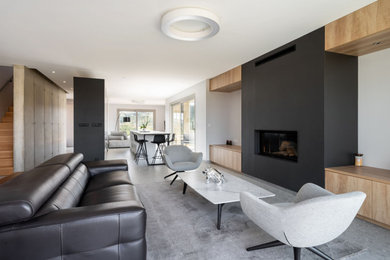 Cette image montre un grand salon minimaliste ouvert avec un mur gris et une cheminée standard.