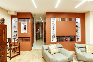 На фото: гостиная комната в восточном стиле с с книжными шкафами и полками, бежевыми стенами, светлым паркетным полом и мультимедийным центром с