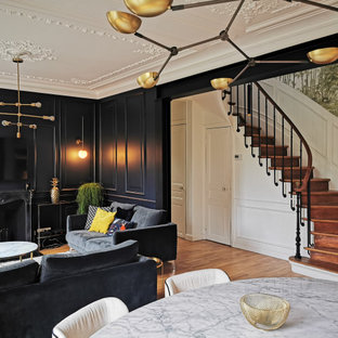 Idées déco pour un salon classique de taille moyenne et ouvert avec un mur noir, un sol en bois brun, une cheminée standard, un manteau de cheminée en métal, un téléviseur fixé au mur et un sol marron.