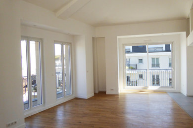 Imagen de salón abierto minimalista de tamaño medio con paredes blancas, suelo de madera en tonos medios y vigas vistas