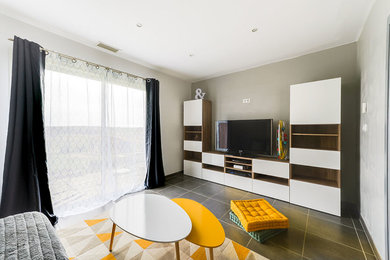 This is an example of a medium sized scandi enclosed living room in Toulouse with beige walls, ceramic flooring, no fireplace, a freestanding tv and grey floors.