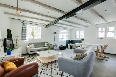 Ejemplo de salón abierto nórdico de tamaño medio sin chimenea con paredes blancas, televisor independiente y suelo gris