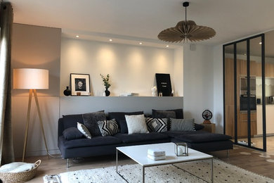 Idée de décoration pour un grand salon minimaliste ouvert avec un mur blanc, parquet clair, un téléviseur indépendant et un sol beige.