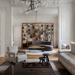 Cette image montre un salon design fermé avec un mur blanc, un sol en bois brun et un sol marron.
