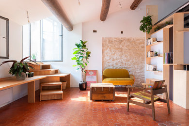 Aménagement d'un petit salon contemporain ouvert avec une bibliothèque ou un coin lecture, un mur blanc et tomettes au sol.