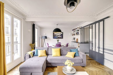 Large scandinavian formal open plan living room in Paris with white walls and light hardwood flooring.