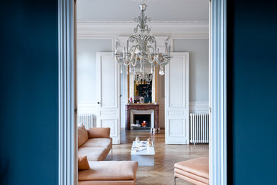 Großes, Repräsentatives, Fernseherloses, Abgetrenntes Modernes Wohnzimmer mit blauer Wandfarbe, braunem Holzboden, Kamin und Kaminumrandung aus Stein in Bordeaux
