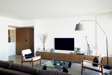 Imagen de salón abierto escandinavo grande con paredes blancas, televisor colgado en la pared y suelo gris