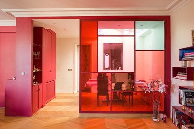 Ejemplo de salón abierto contemporáneo de tamaño medio sin chimenea y televisor con paredes rojas, suelo de madera clara y suelo beige