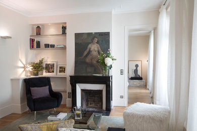 Cette photo montre un grand salon chic ouvert avec un mur beige, parquet clair, une cheminée standard, un manteau de cheminée en pierre et un sol marron.