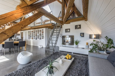 Aménagement d'un salon contemporain ouvert avec un mur blanc, une cheminée standard, un manteau de cheminée en métal, un sol gris et éclairage.