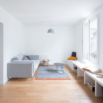 Mid-sized danish formal and enclosed light wood floor and brown floor living room photo in Paris with white walls, no tv and no fireplace