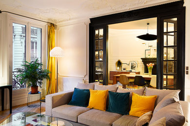 パリにあるお手頃価格の広いコンテンポラリースタイルのおしゃれなLDK (ベージュの壁、濃色無垢フローリング、茶色い床、標準型暖炉) の写真